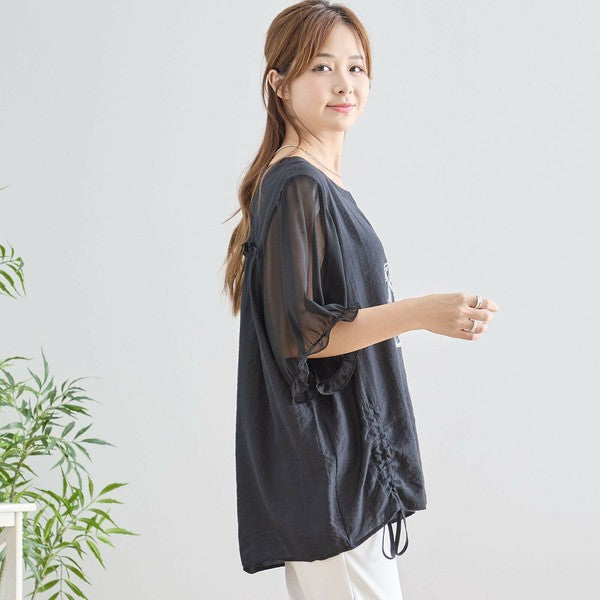 ドルマン袖のブラックTシャツを着た女性モデルの横向きコーディネート