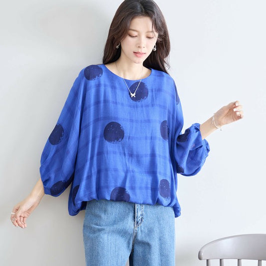 鮮やかなブルーの大ドットブラウス モデルが前向きに立ってナチュラルな雰囲気