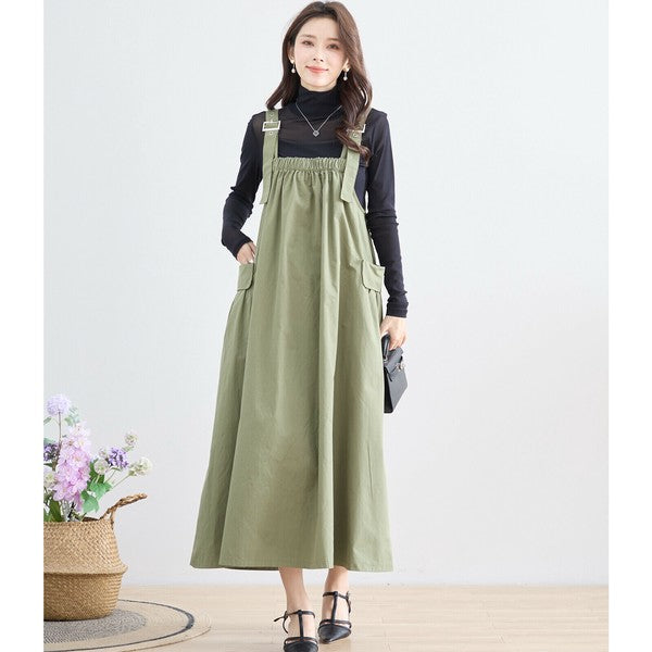 カーキのジャンパースカートと黒トップスのコーデ 上品なナチュラルカジュアル