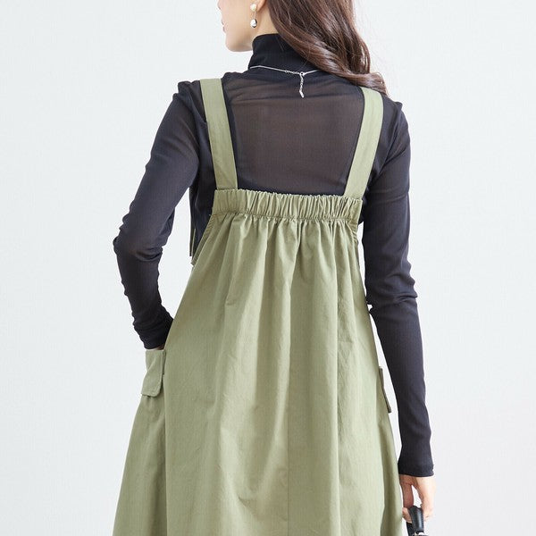 カーキカラーのジャンパースカートを後ろから撮影 肩ひもとギャザーの背面デザインが確認できる一枚