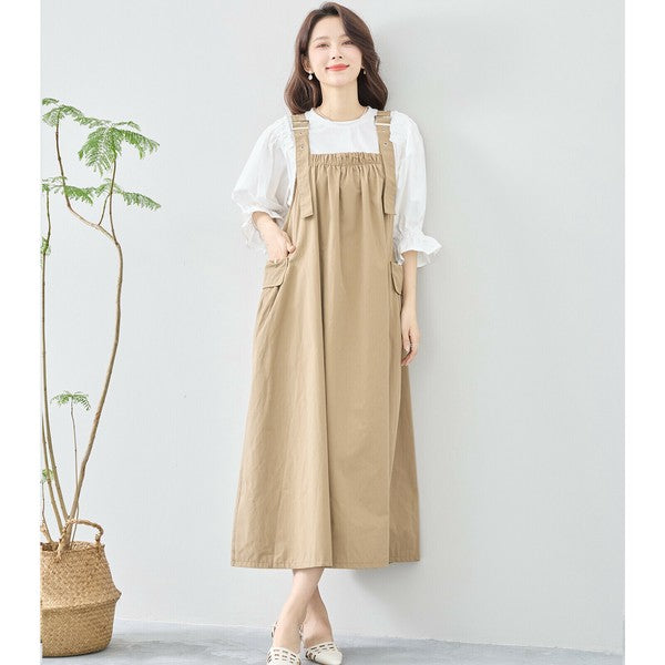 ベージュのジャンパースカートを着用 ナチュラルで軽やかな印象の全身カット