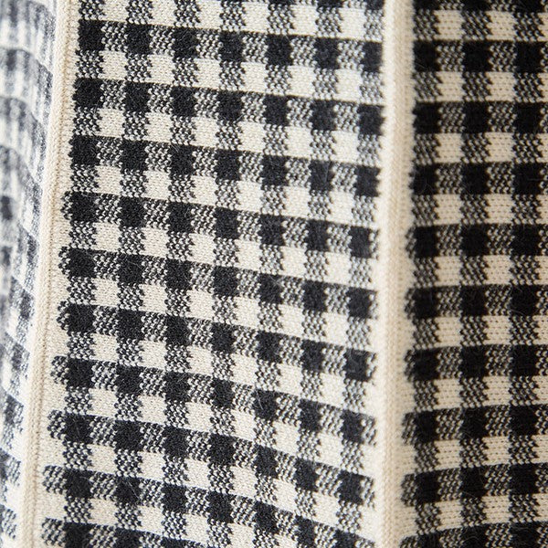 Mikonosublue Storeのニットワンピースに使用されている、上品なモノトーンのチェック柄と配色ラインのディテール