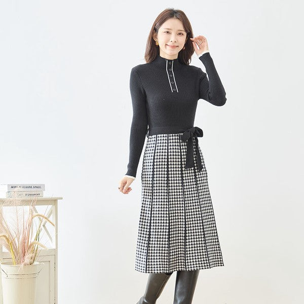 Mikonosublue Storeのハイネックニットワンピース。黒のリブニットとチェック柄フレアスカートのドッキングデザインで、ウエストリボンが特徴的。