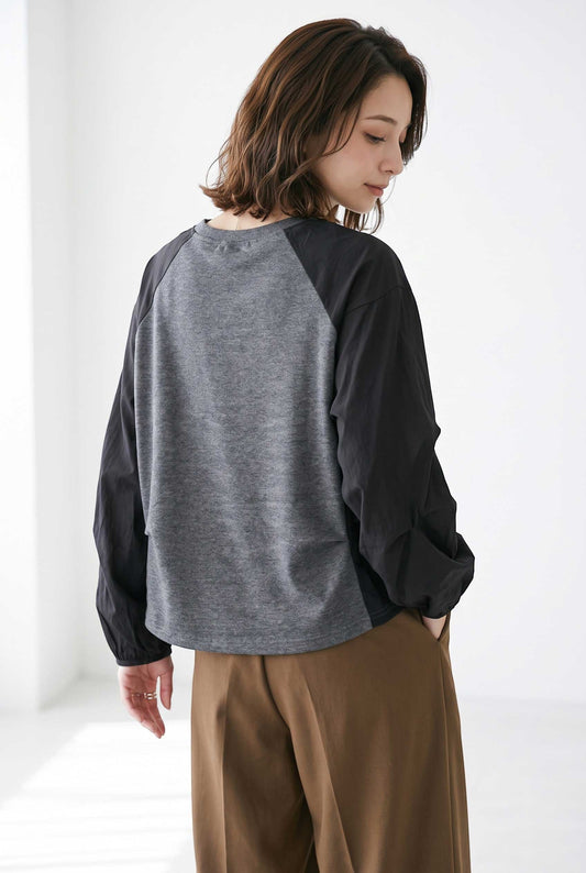 Mikonosublue Store grey and black raglan pullover with voluminous pleated sleeves worn by a woman