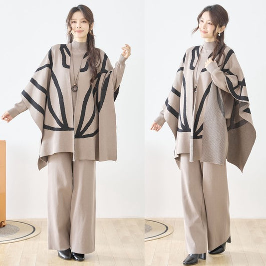 ベージュのポンチョ風ニットを着用したモデルが斜め前を向いて立っている。ナチュラルカラーのセットアップと合わせたリラックス感あるコーデ。