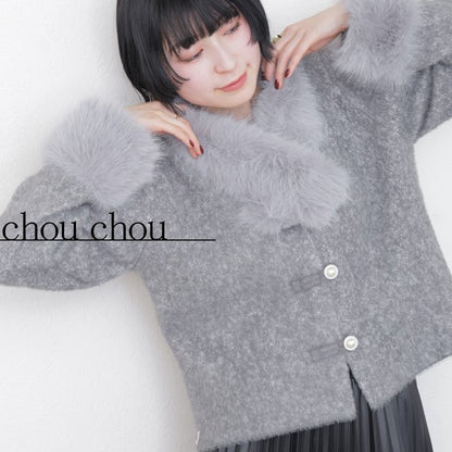 グレーのニットカーディガンを着た女性モデルが笑顔でポーズ