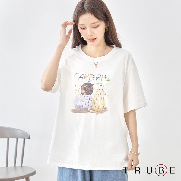 猫柄プリントTシャツを着用したモデルの正面。顔周りを明るく見せるクリーンなホワイト地と、程よい開きのクルーネック。