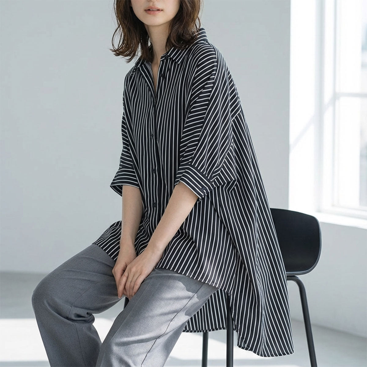 ブラック×ホワイトのストライプ柄。首元がすっきり見えるデザインと、二の腕をカバーするドルマンスリーブのフロントスタイル。