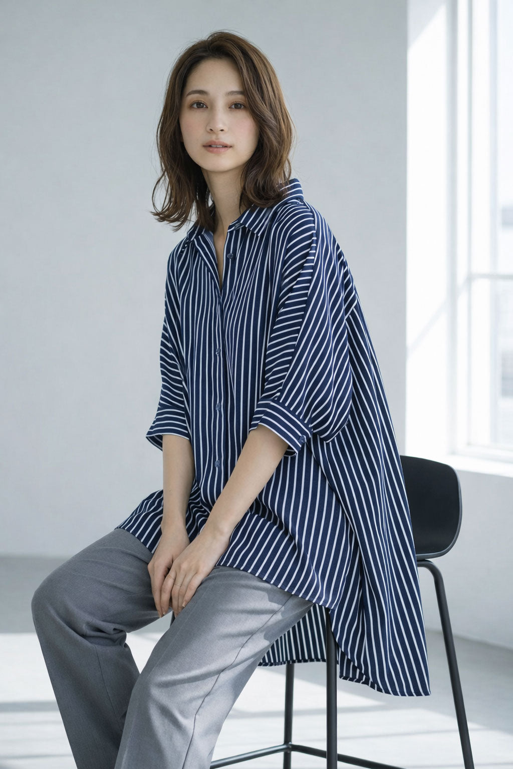 ネイビー系のストライプ柄チュニックシャツ。落ち着いた色合いで、知的な印象を与えるカラーバリエーション。