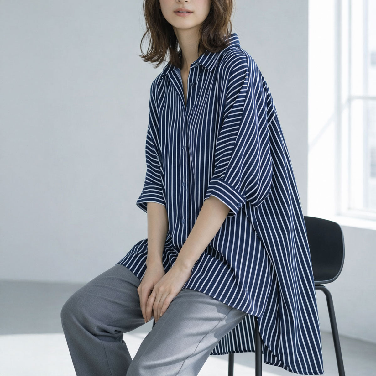 ネイビー系のストライプ柄チュニックシャツ。落ち着いた色合いで、知的な印象を与えるカラーバリエーション。