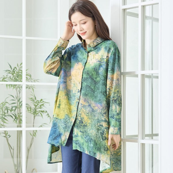 グリーンを基調とした抽象的なアートプリント柄のフロントショット。首元をすっきり見せるバンドカラーデザイン。