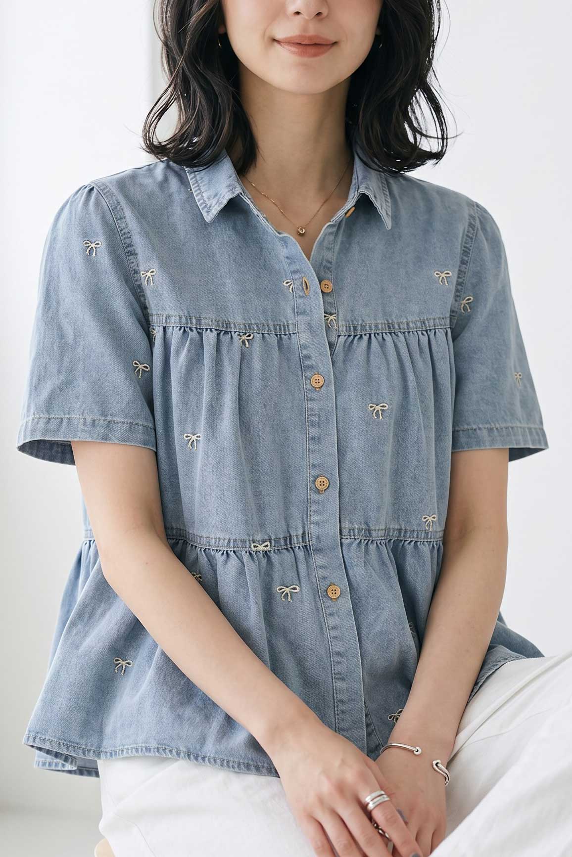 椅子に座るモデルの正面カット。リラックスした着心地ながら、カジュアルすぎず「大人可愛い」きれいめな装いを提案。