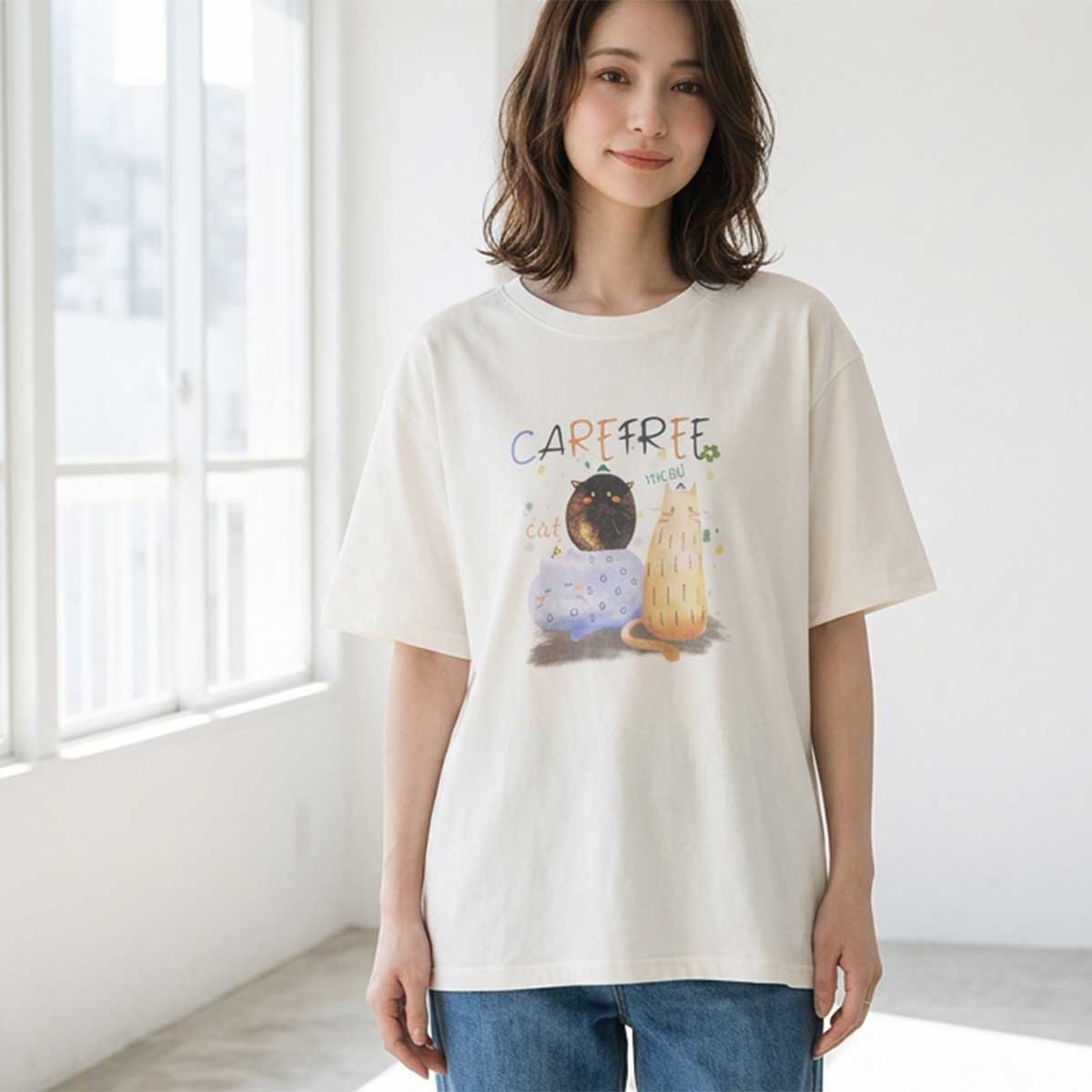2匹の仲良しな猫が並んで座っているイラストが描かれたホワイトTシャツ。綿100%素材の柔らかな風合いと、ほっこりする猫柄プリントが魅力。