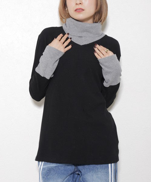 グレーのインナー風袖を見せたブラックのレイヤードカットソーを着た女性（正面）
