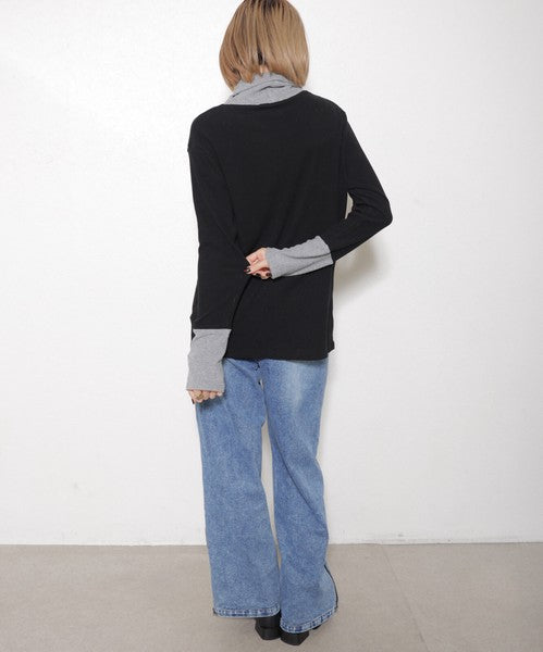 バックスタイルを見せる立ち姿（ブラック×グレーのバイカラートップス）