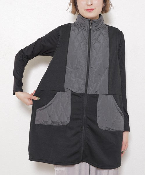 正面からロングベストを着た女性モデル（手を腰に