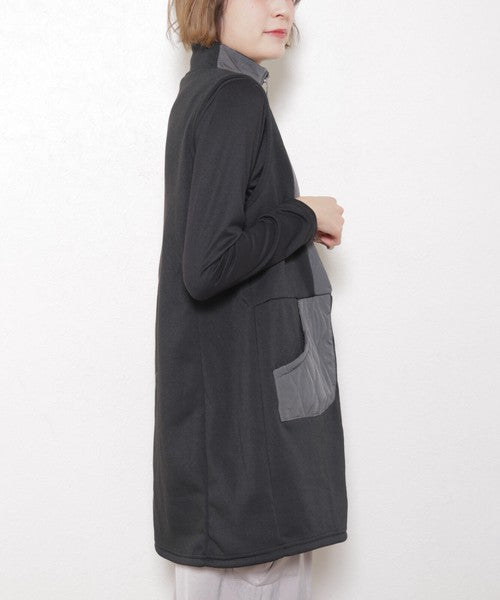 横向きに立つモデルがベストのポケットに手を入れている様子
