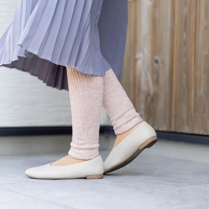 ピンクのレッグウォーマーを着用して外を歩く女性（フラットシューズ）