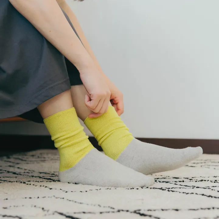 蛍光イエローのソックスを履くシーン（着用途中）