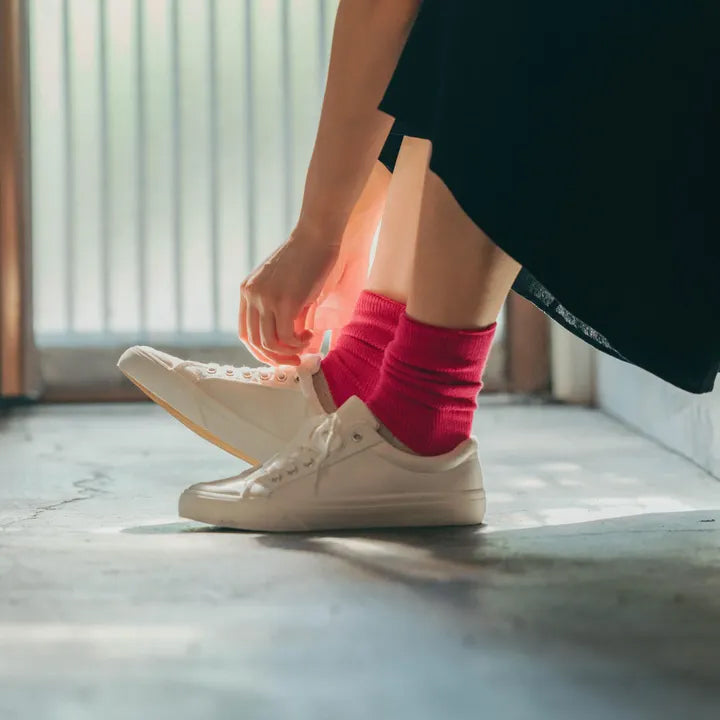 ピンクの配色ソックスを履く瞬間の足元アップ