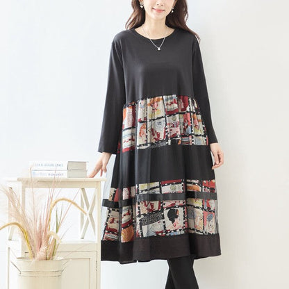 Mikonosublue Storeの異素材切替ロングワンピース。アートなコラージュ柄とブラックの無地を組み合わせた、ゆったりとしたシルエットの長袖ドレス。