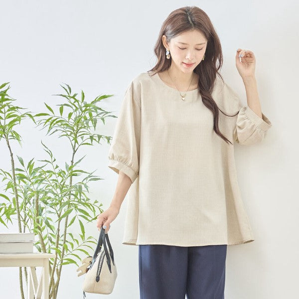 Mikonosublue StoreのベージュのAライントップス。5分袖でゆったりとしたシルエット、二の腕をカバーするフェミニンなデザイン。