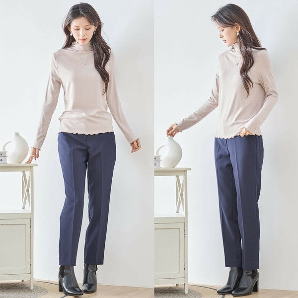 Mikonosublue Storeのベージュのメロウフリルハイネックリブカットソーを着用した女性の全身コーディネート