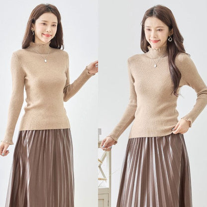 Mikonosublue Storeのベージュのリブニットプルオーバー。首元と袖口のフリルが特徴のハイネック長袖トップス。