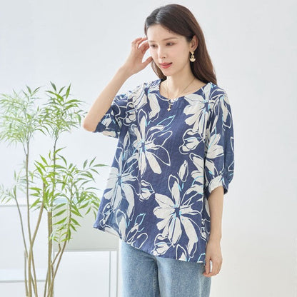Mikonosublue Storeのネイビー地に白い大きな花柄がプリントされた綿100%のゆったりとしたドルマン袖トップス