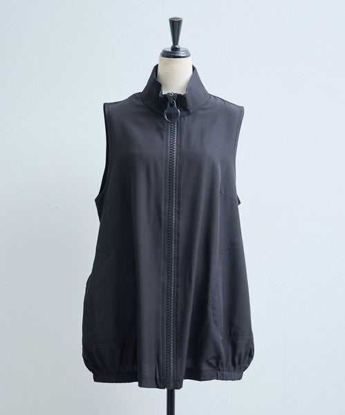 Mikonosublue Storeの黒いロングジレ。大きなリングジップと丸ポケットが特徴で、裾がゴム仕様のコクーンシルエット。