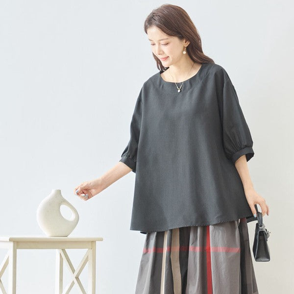 Mikonosublue Storeの黒い5分袖Aライントップス。ゆったりとしたシルエットで二の腕をカバーし、さらりとした素材で夏に快適なきれいめカジュアルスタイル。