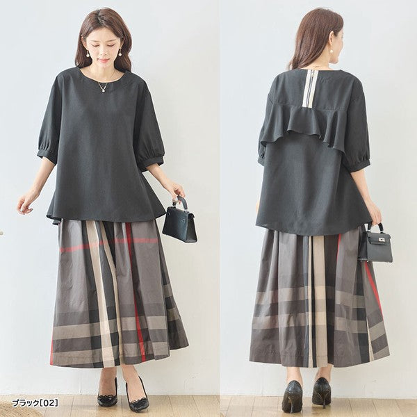 Mikonosublue Storeのバックフリルが特徴的な黒の5分袖Aライントップス。後ろ姿のファスナーとフリルが華やかな体型カバーデザイン。