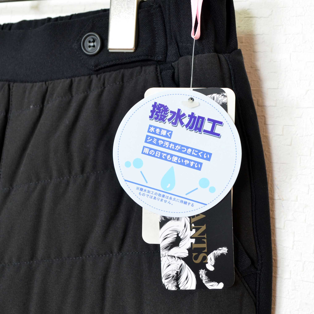 Mikonosublue Storeの撥水加工タグが付いた黒のキルティングダウンパンツ。ウエストゴム仕様で機能的な防寒ボトムス。