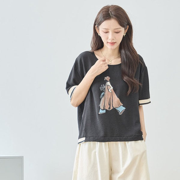 Mikonosublue Storeのファッションイラストがプリントされた黒の半袖トップス。配色リブとドロップショルダーが特徴のゆったりとしたデザイン。