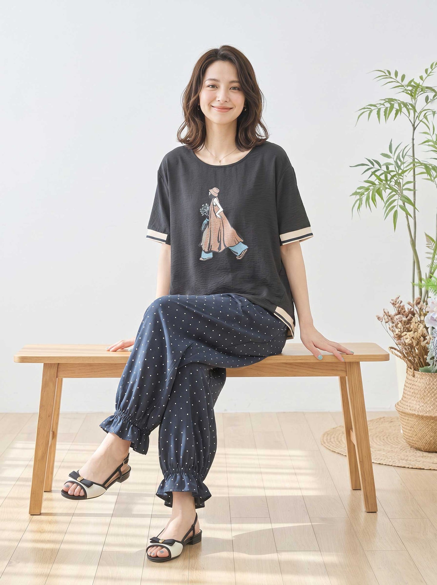 Mikonosublue Storeのファッションイラストがプリントされた黒のゆったり半袖トップスを着た女性