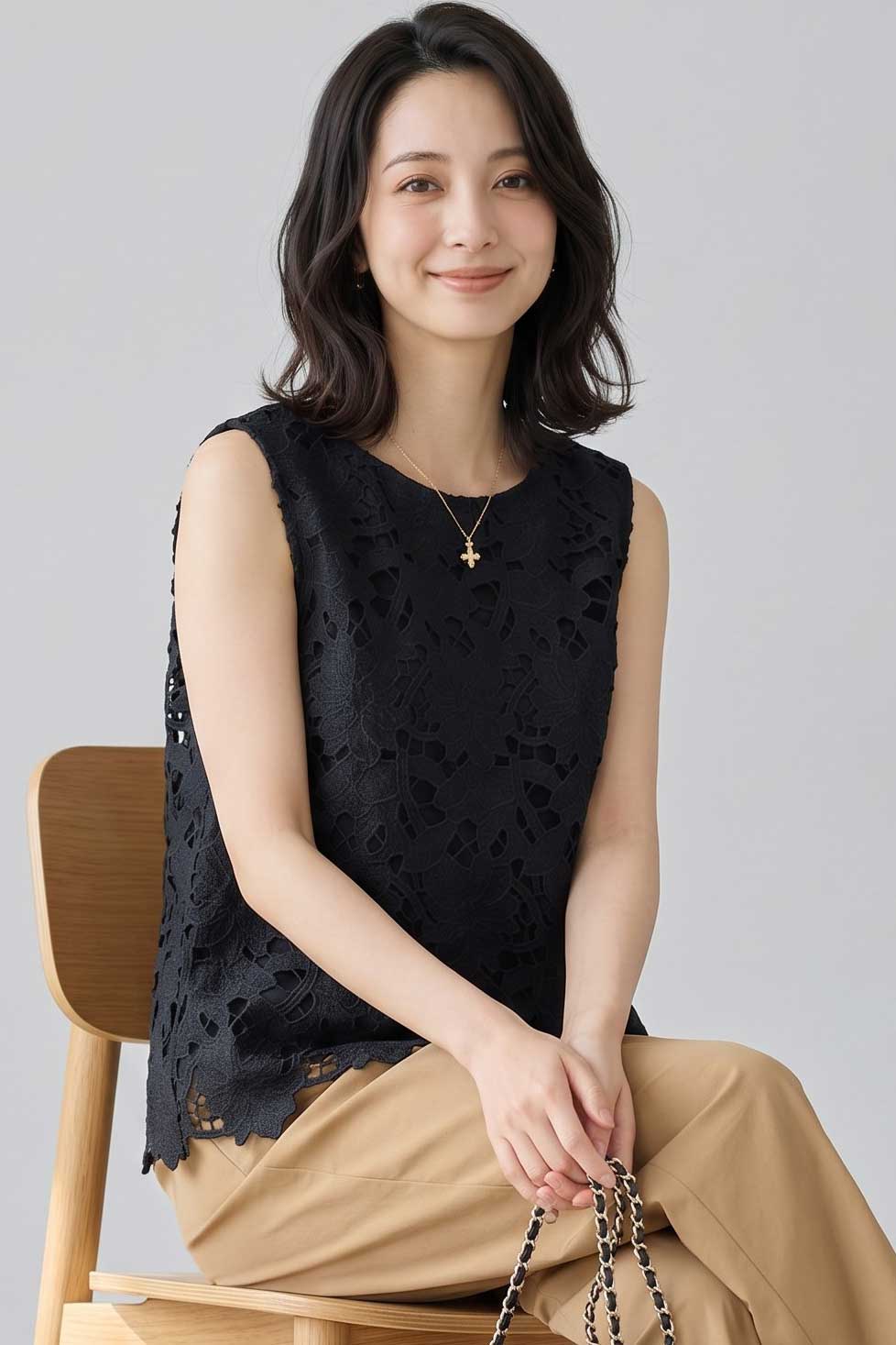 Mikonosublue Storeの黒い花柄カットワークレースノースリーブトップス。裾スカラップのゆったりした綿素材で上品な大人カジュアルスタイル