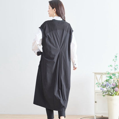 Mikonosublue Storeの黒い異素材切り替えノースリーブロングワンピース。バックタック入りのAラインシルエットで、白いブラウスとレイヤードしたコーディネート。
