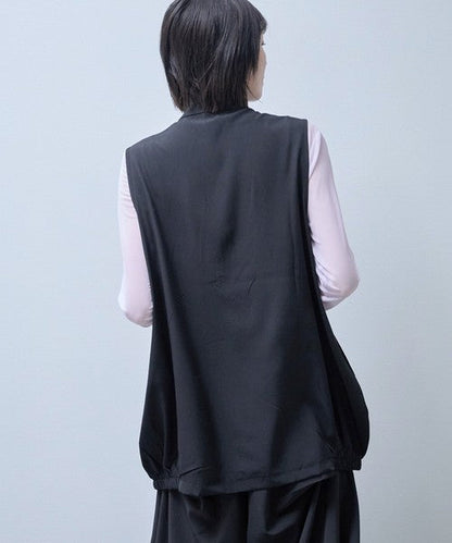 Mikonosublue Storeの黒いロングジレ。背中側から見たシルエットで、裾のゴムによるコクーン風の形が特徴。