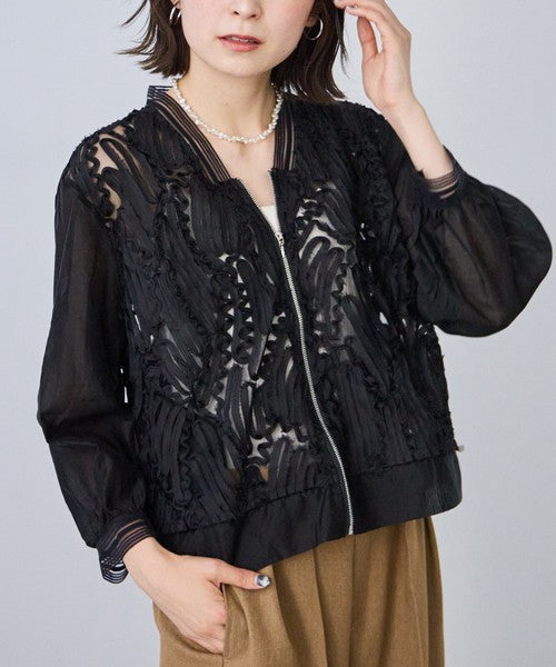 Mikonosublue Storeのコード刺繍が施された黒のシアーブルゾン。透け感のある素材と裾ドロスト仕様が特徴の長袖ライトアウター