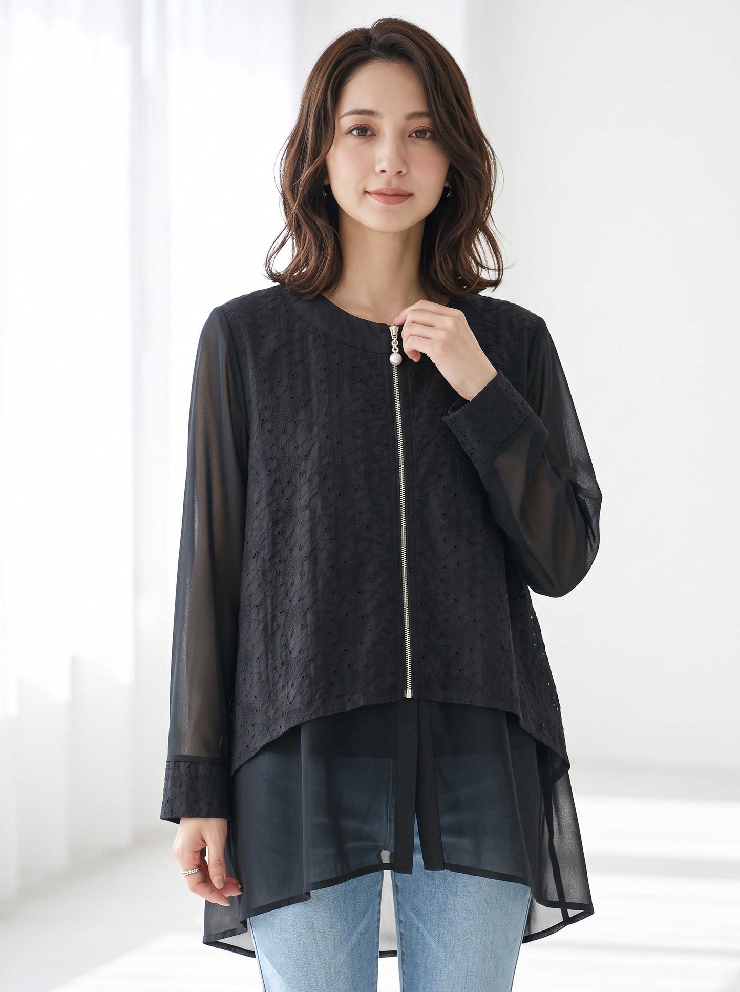 Mikonosublue Storeの黒いシアーレースジャケット。カットワークレースと透け感素材の異素材切替、パールボタン付きジップアップ、バックロング丈が特徴。