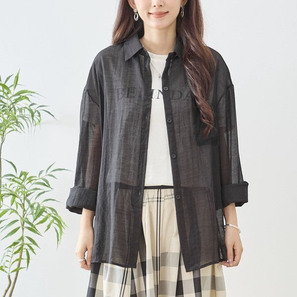 Mikonosublue Store black sheer long-sleeve shirt with floral lace details and a relaxed fit, worn over a white t-shirt.