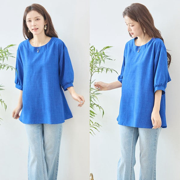 Mikonosublue Storeの鮮やかなブルーの5分袖Aライントップス。バックフリルとファスナーが特徴で、ゆったりとしたシルエットが体型をカバーします。