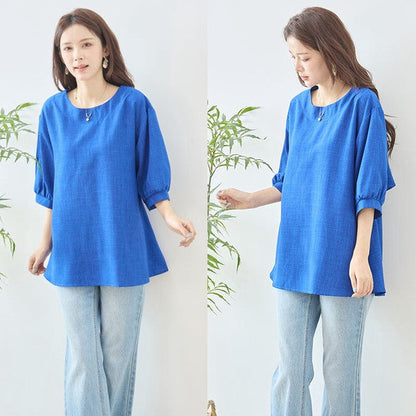 Mikonosublue Storeの鮮やかなブルーの5分袖Aライントップス。バックフリルとファスナーが特徴で、体型カバーも叶うゆったりとしたシルエット。