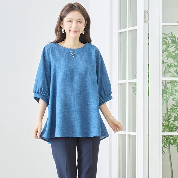 Mikonosublue Storeの青いAライントップス。5分袖でゆったりとしたシルエットが特徴の体型カバーできる夏用ブラウスを着用した女性。