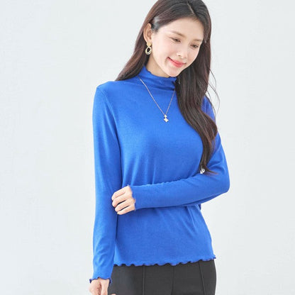 Mikonosublue Storeの鮮やかなブルーのハイネックリブカットソー。首元と袖口に大人可愛いメロウフリルをあしらった長袖インナー。