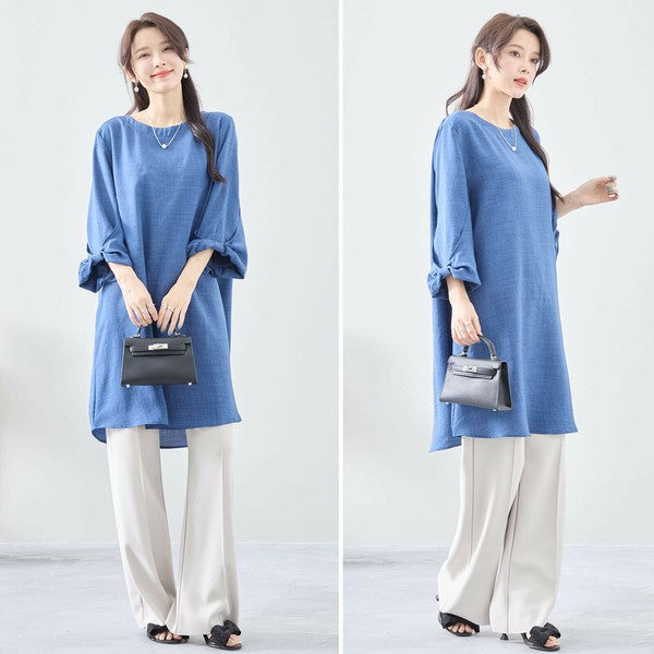 Mikonosublue Storeの袖口リボンが可愛い青色のAラインチュニックワンピースを着用した女性