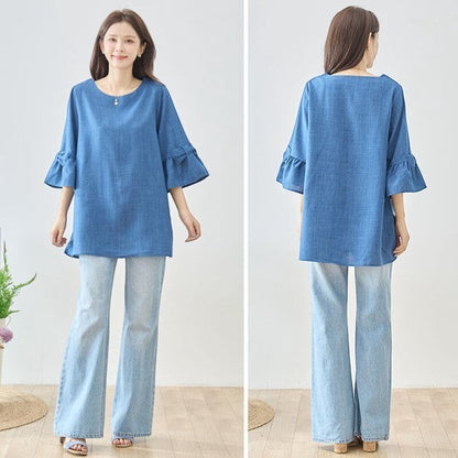 Mikonosublue Storeの袖リボン付きブルーチュニックブラウス。七分袖のAラインシルエットで体型カバーも叶うフェミニンなデザイン。