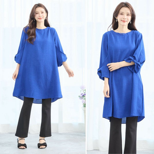 Mikonosublue Storeの袖口リボンが可愛いブルーのAラインチュニックワンピース。ゆったりとしたシルエットで体型カバーも叶う七分袖の大人フェミニンな一着。