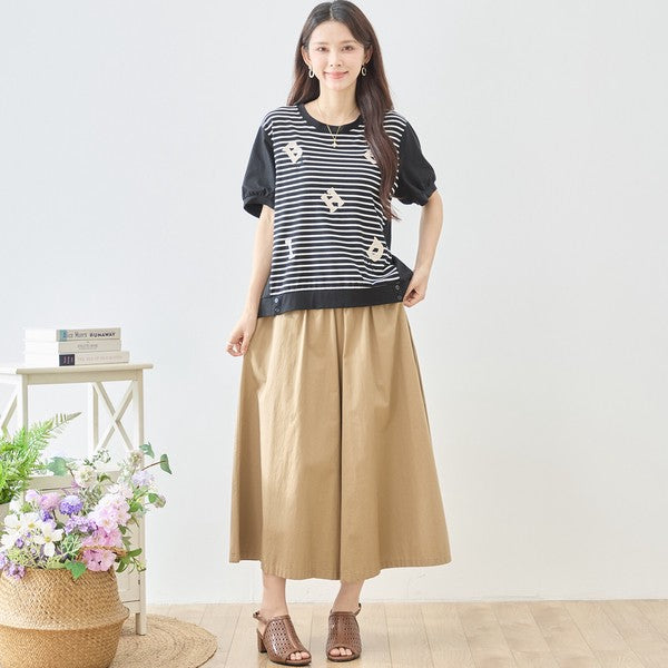 Mikonosublue Storeのアルファベット刺繍入りボーダー切り替え半袖Tシャツを着用した女性。ゆったりとしたシルエットで体型カバーも叶うカジュアルなトップス。