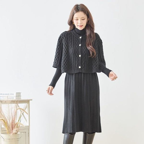 Mikonosublue Storeの黒いケーブル編みボレロとリブニットワンピースのセットアップを着用した女性